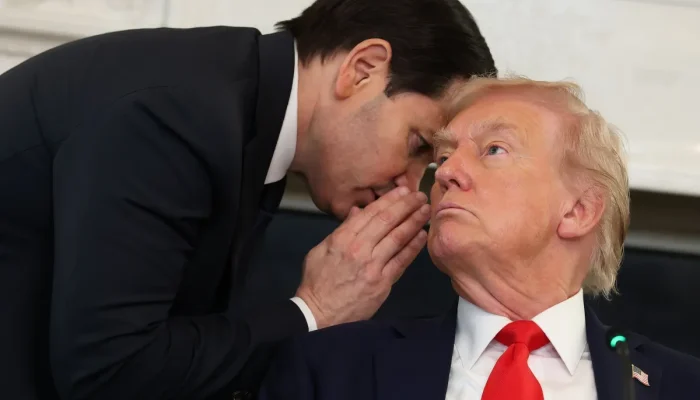O Secretário de Estado dos EUA, Marco Rubio (à esquerda), conversa com o Presidente dos EUA, Donald Trump, durante uma mesa-redonda na Sala de Jantar de Estado da Casa Branca, em 8 de outubro de 2025, em Washington, DC.  • Anna Moneymaker/Getty Images